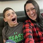 Smiling woman and boy enjoying community gathering at Foundation for Intentional Community.
