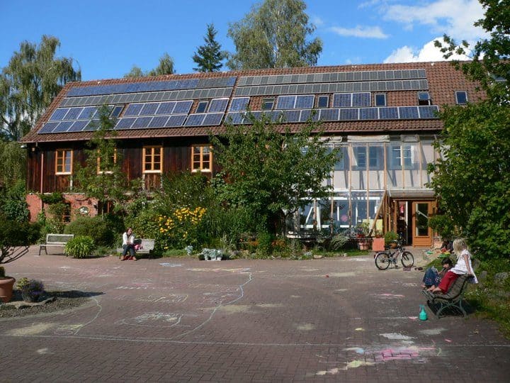 Community building with solar panels and outdoor seating area.