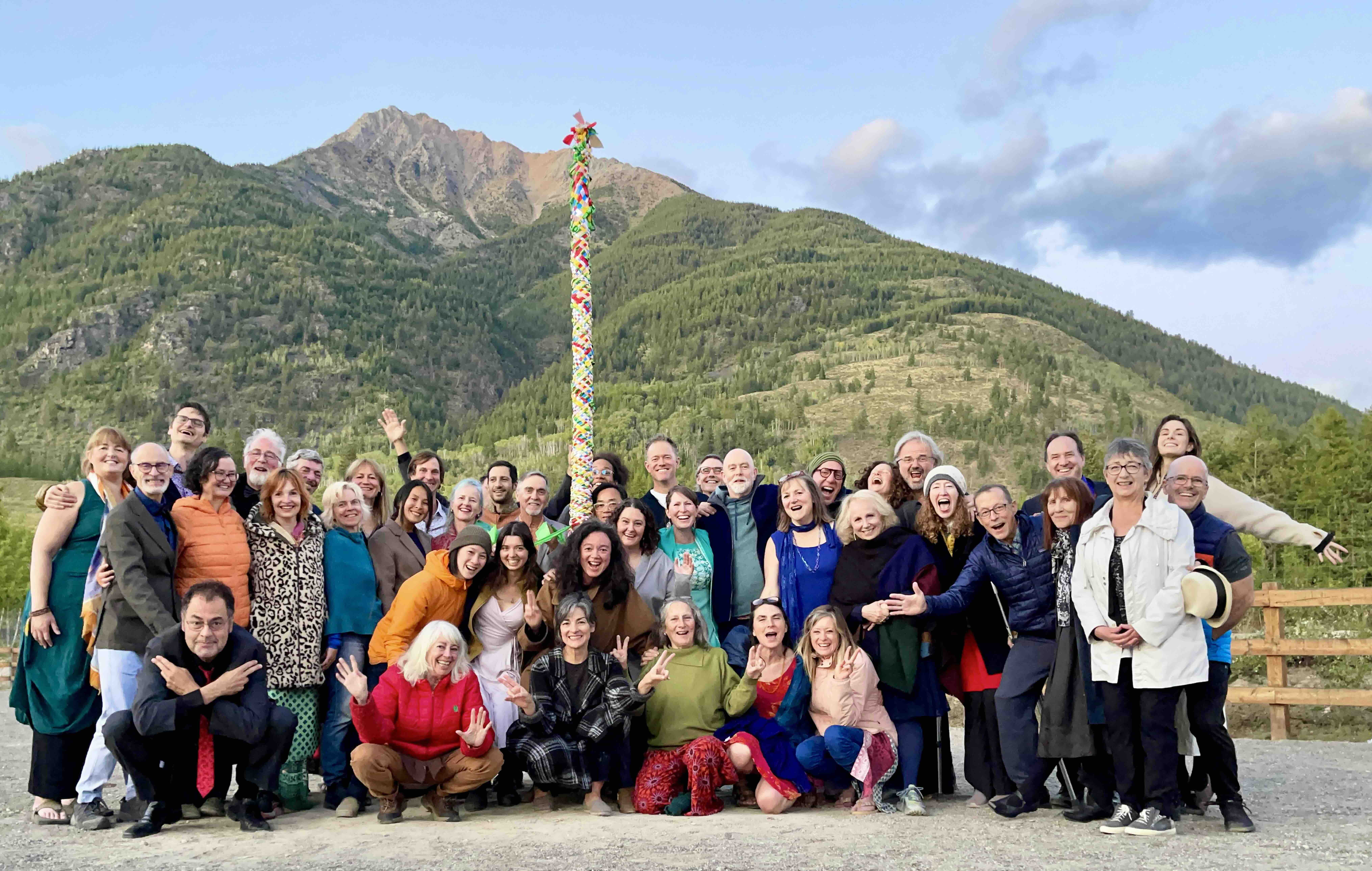 Diverse group of people outdoors with mountains in the background.