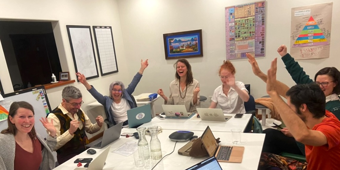 Happy diverse group celebrating success in a professional meeting room.